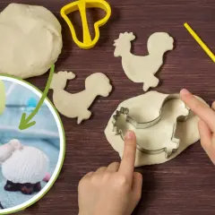 Dzieci tworzą baranka wielkanocnego diy z ciasta. Widać foremkę, wałek i pisanki.