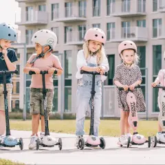 Fizjoterapeuta poleca Scoot and Ride dla dzieci. Pięcioro maluchów w kaskach na hulajnogach, gotowych do zabawy.