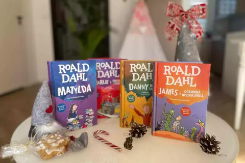 Książki Roald Dahl: Matylda, Charlie i fabryka czekolady, Danny, James i olbrzymia brzoskwinia. W tle świąteczne dekoracje.