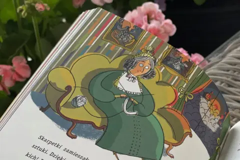 Ilustracja z książki "Sekretna historia skarpetek". Starsza pani w zielonej sukni siedzi na fotelu i dzierga.