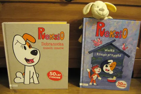 Dwie książki z Reksio: "Dobranocka wszech czasów" i "Wielka księga przygód". Na okładce drugiej widać Reksia w budzie i kota.