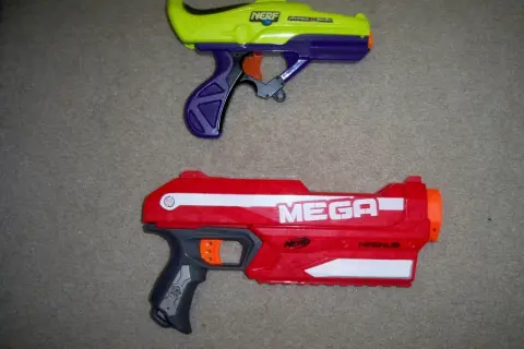 Dwa pistolety Nerf: żółto-fioletowy i czerwony Nerf Magnus.