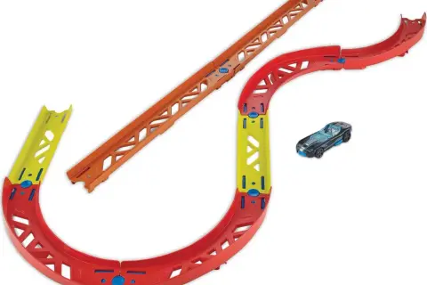 Tor wyścigowy Hot Wheels z czerwonymi zakrętami, żółtym mostkiem i pomarańczowym odcinkiem prostym. Obok czarny samochodzik.